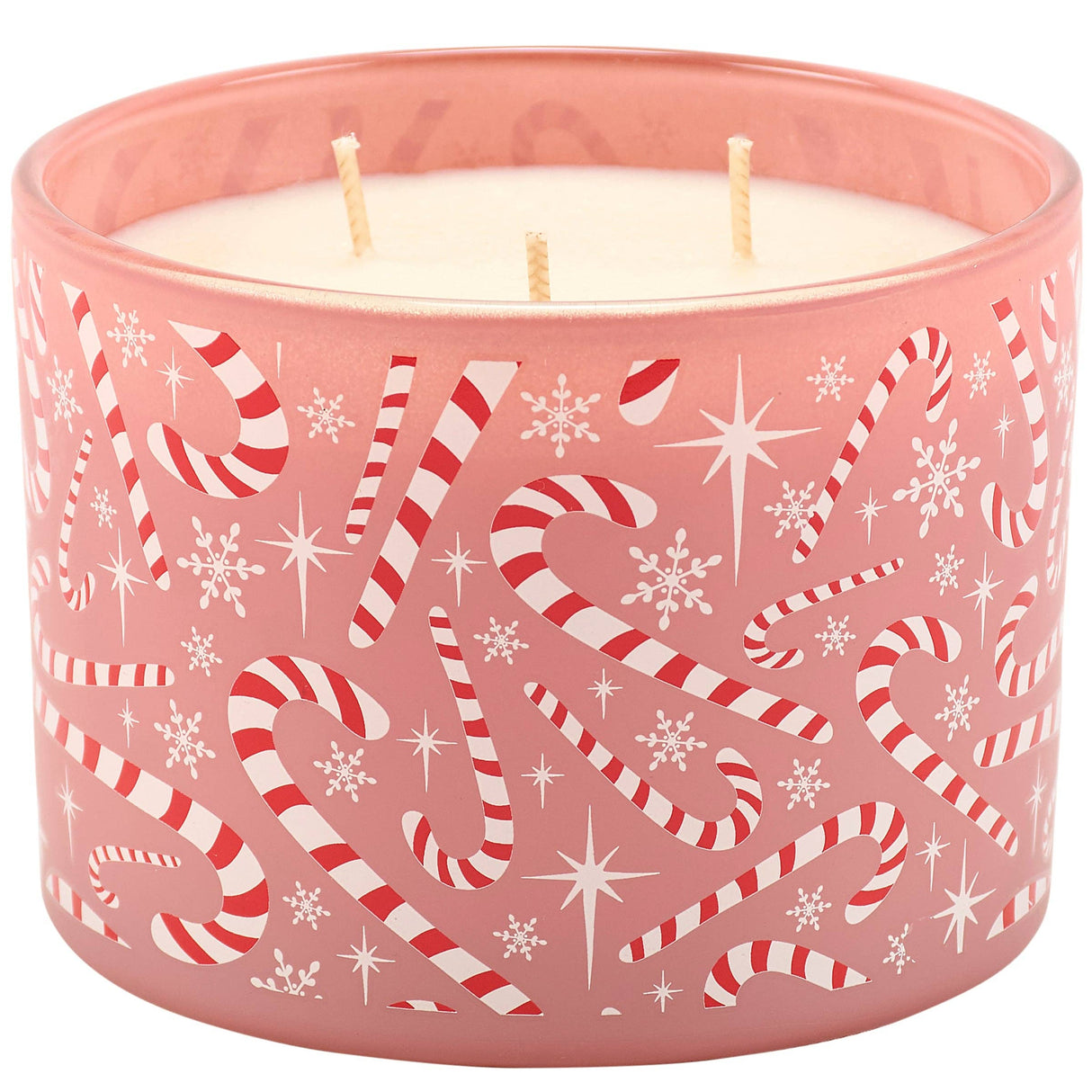 A pink frosted glass jar candle with three wicks, decorated with a festive pattern of red and white striped candy canes, white snowflakes, and white starbursts.