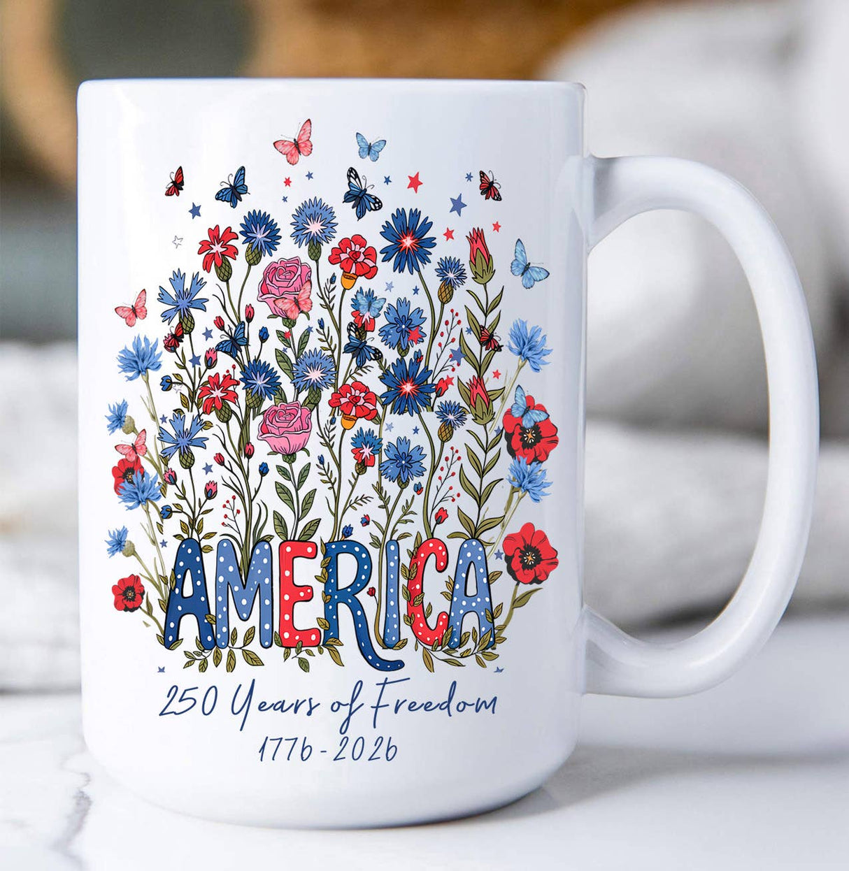 15oz ceramic mug with red, white, and blue florals, butterflies, and “America – 250 Years of Freedom 1776–2026” design.