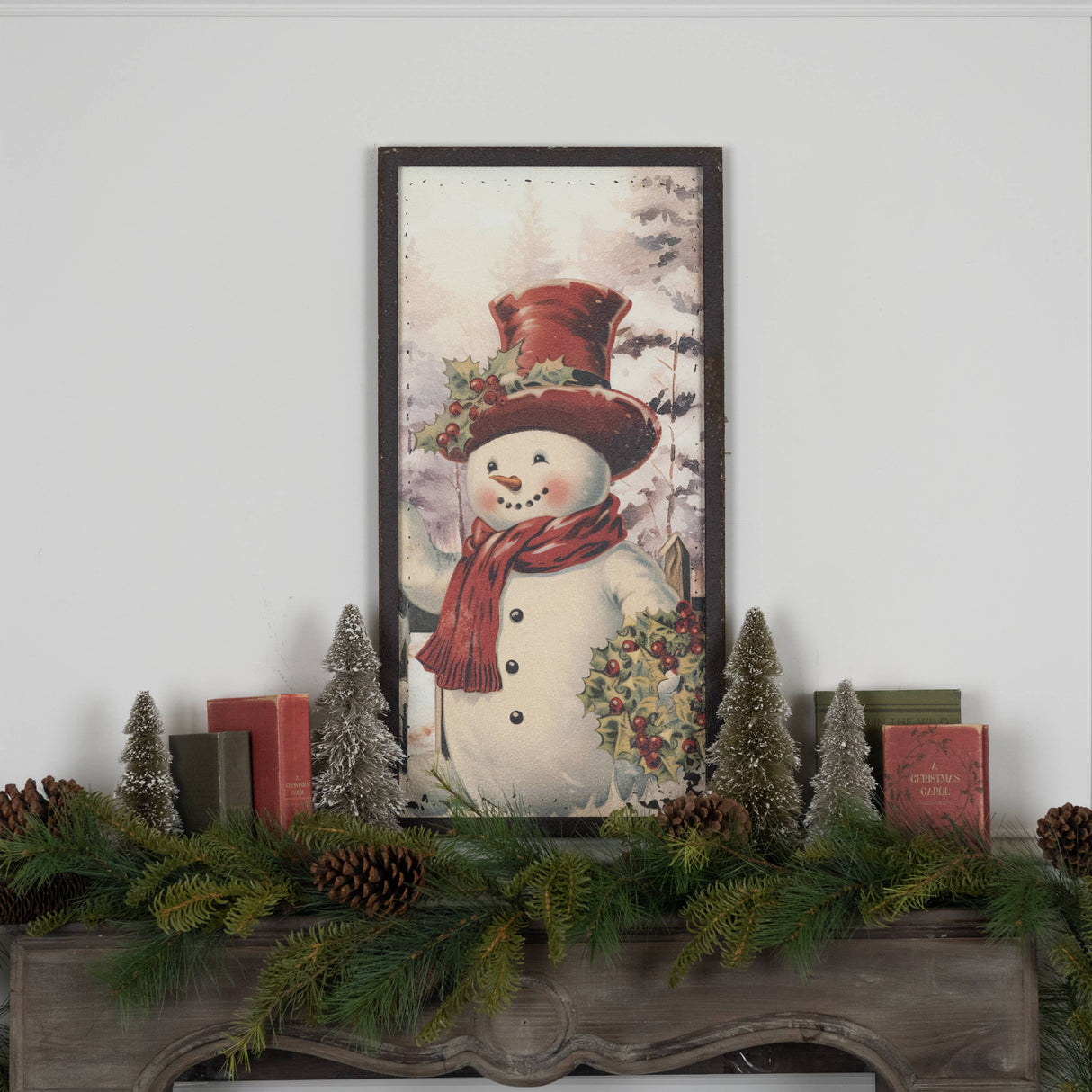 Hand‑painted metal snowman wall hanging with red hat and scarf in a snowy evergreen scene.
