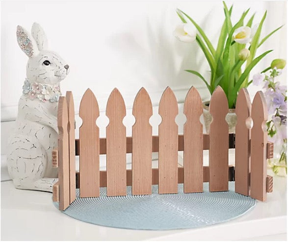 Wooden picket fence with a decorative rabbit and plants on a white background