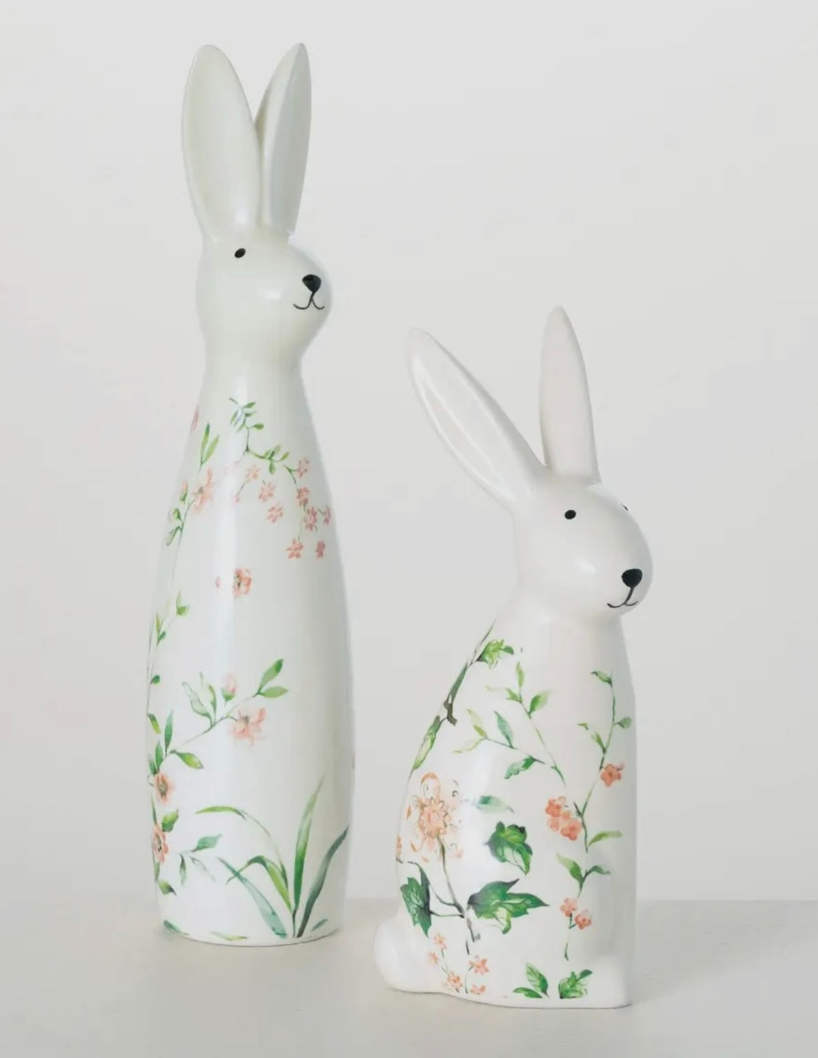 Set of two floral bunny figurines, one 9″ and one 12″ tall, with pastel flower accents—spring decor by Sullivans.
