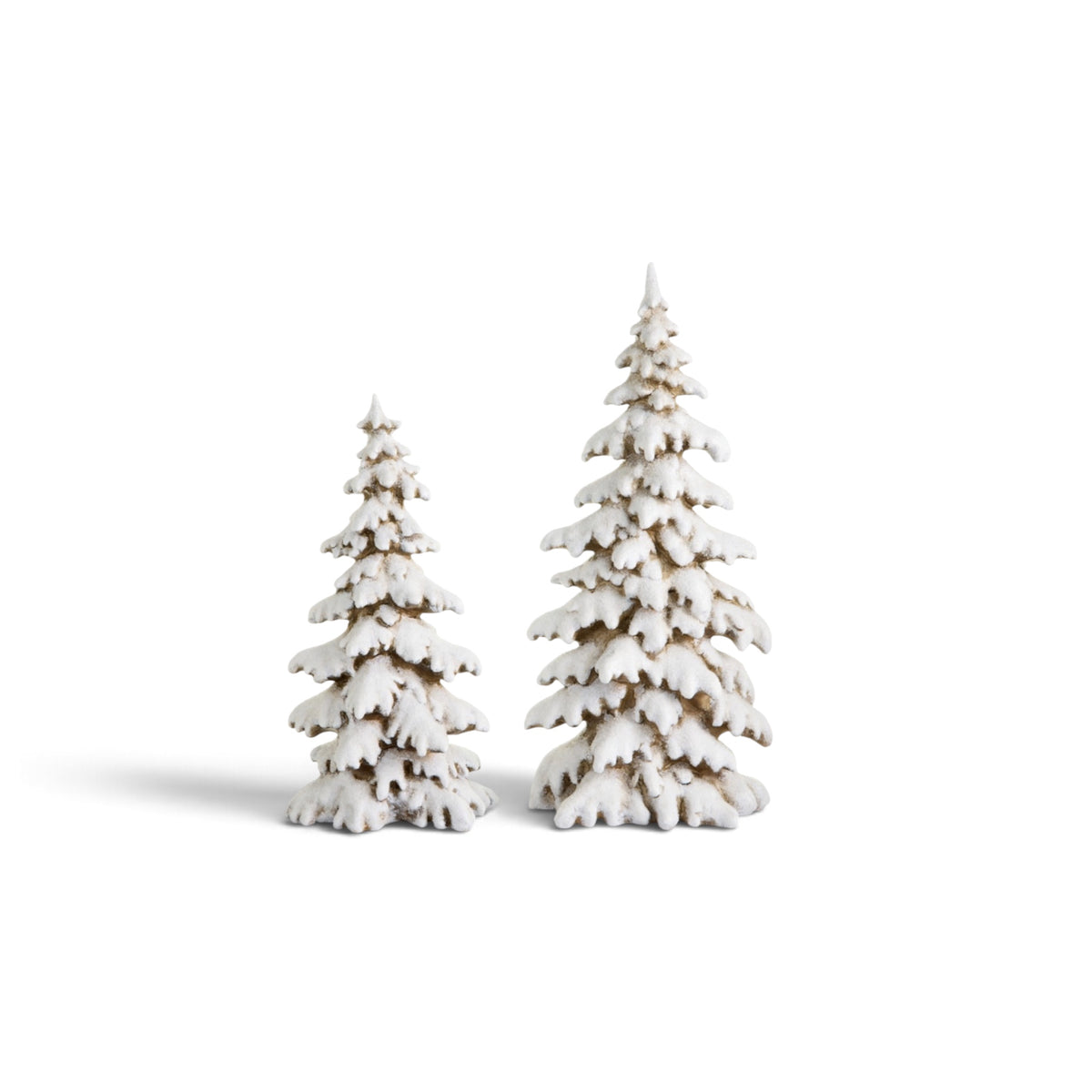 A set of two snowy woodland evergreen trees feature heavily snow-covered branches with realistic layered detailing. The natural tree trunks and branches peek through the snowy finish, creating the appearance of freshly snow-laden evergreens in a winter forest. The set includes two coordinating trees, with the tallest measuring 20 inches high.