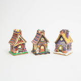 Witch’s Candy Corn Cottage: Lighted Halloween gingerbread house with candy corn awning, cupcakes on the roofline, a purple‑clad witch, a small ghost, and a bat in the attic window.

Ghostly Coffin Cottage: Lighted Halloween gingerbread house with a coffin‑shaped door, ghost in the attic window, spiderweb front detail, jack‑o‑lanterns, and purple‑yellow roof.

Ghost & Gravestone Gingerbread House: Lighted Halloween gingerbread house with a ghost out front, tombstones beside the door, jack‑o‑lantern roofline,