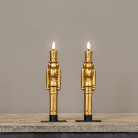 Gold nutcracker LED taper candles in 9.75" heights, featuring a sculpted design and realistic 3D flame.