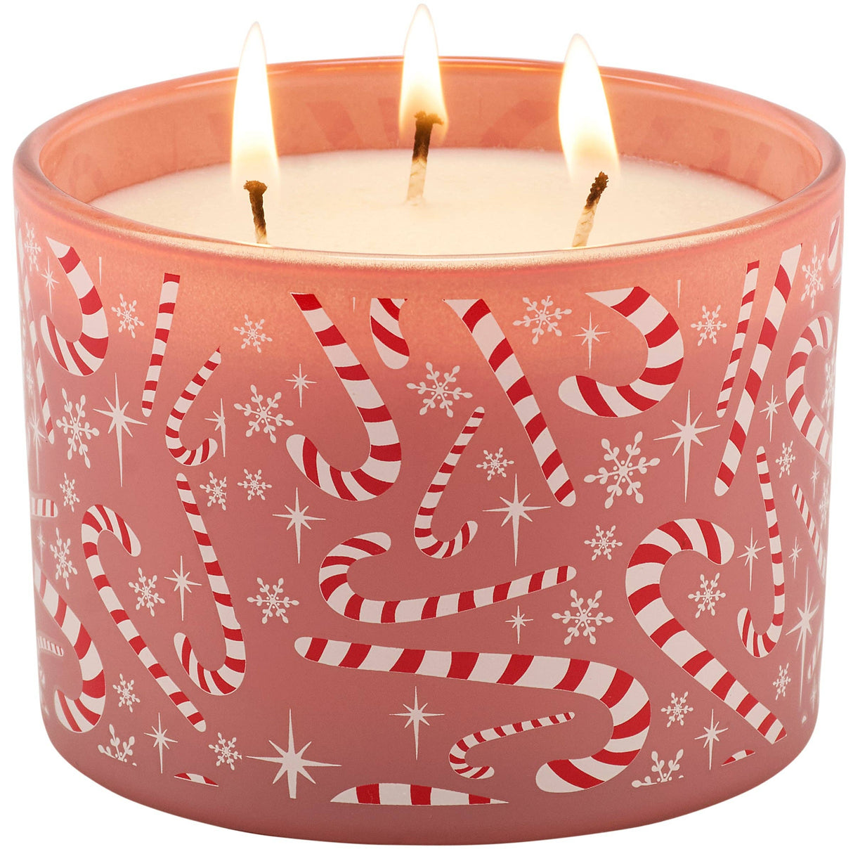 A three-wick holiday candle in a frosted pink glass container with red and white candy cane and snowflake patterns, shown lit on a white background.