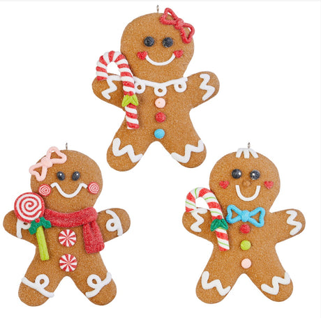 Three decorative gingerbread men with candy canes and scarves on a white background