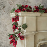 Six‑foot red hops garland draped over a cream mantel with green leaves.