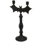 Matte black metal bat‑themed taper candle holder with two candle cups on the wings and a tall decorative base.