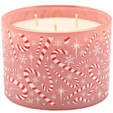 A pink frosted glass jar candle with three wicks, decorated with a festive pattern of red and white striped candy canes, white snowflakes, and white starbursts.