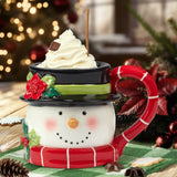 Snowman-themed mug with whipped cream and a candy cane handle on a festive background.