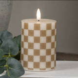 4" Pillar: Gold checked LED pillar candle styled with white books, eucalyptus, and a ceramic vase.