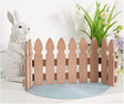 Wooden picket fence with a decorative rabbit and plants on a white background