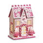Decorative gingerbread house with pink and white icing on a white background
