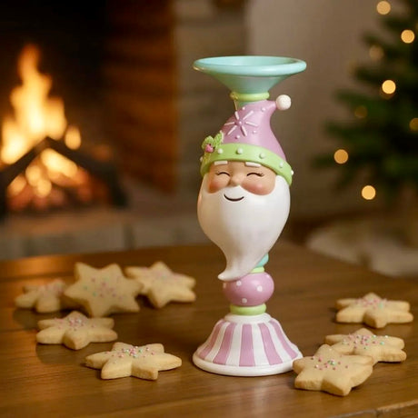 Decorative gnome candle holder on a table with cookies, fireplace, and Christmas tree in the background