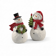 Two flocked snowman figurines feature a soft snow-covered texture and festive red scarves. One snowman wears a black top hat and holds a green holiday wreath, while the other wears a red Santa hat and holds a green Christmas tree. Both figurines are crafted from resin with a realistic flocked finish that resembles freshly fallen snow.