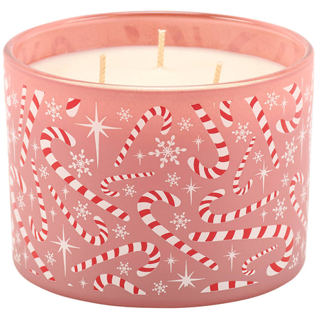 A three-wick candle in a pink glass container decorated with red and white candy canes, snowflakes, and white stars, shown against a plain white background.