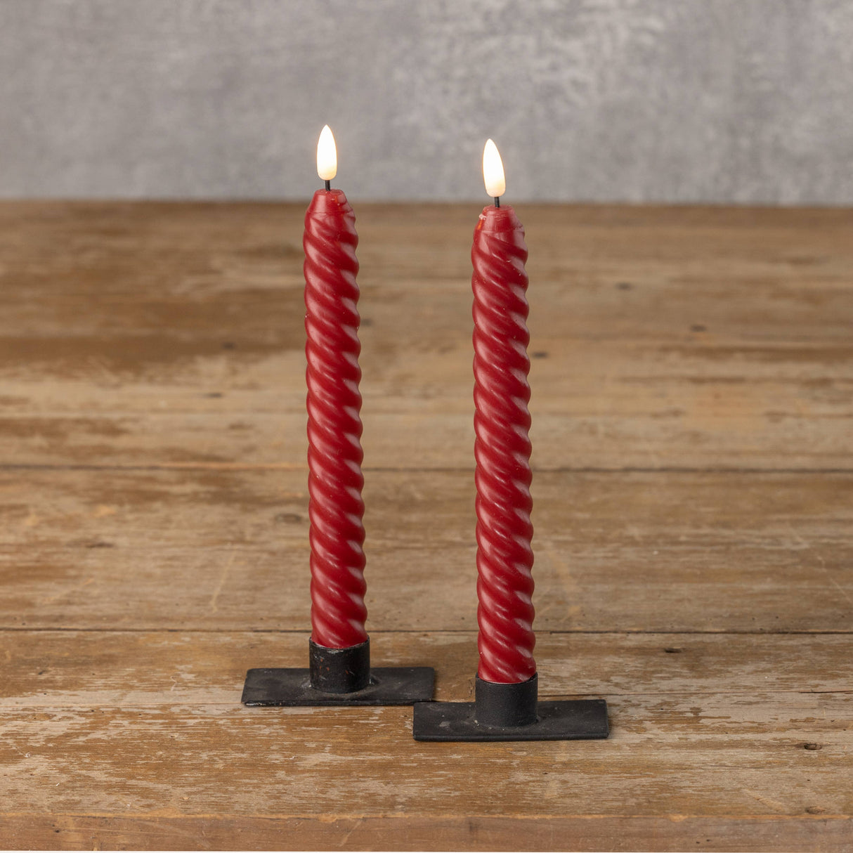 Red spiral LED taper candles with realistic 3D flame styled in black holders.