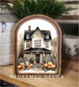 Arched framed canvas featuring a rustic two‑story house surrounded by pumpkins, bare trees, and autumn leaves.