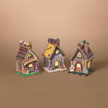 Three small decorative gingerbread-style houses with Halloween-themed roofs and details, arranged side by side on a plain beige background.